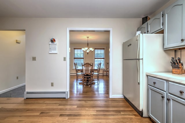 67 Nicole Dr, Naugatuck, CT 06770 - kitchen with a baseboard heating unit, gray cabinets, light wood-type flooring, freestanding refrigerator, and a chandelier
