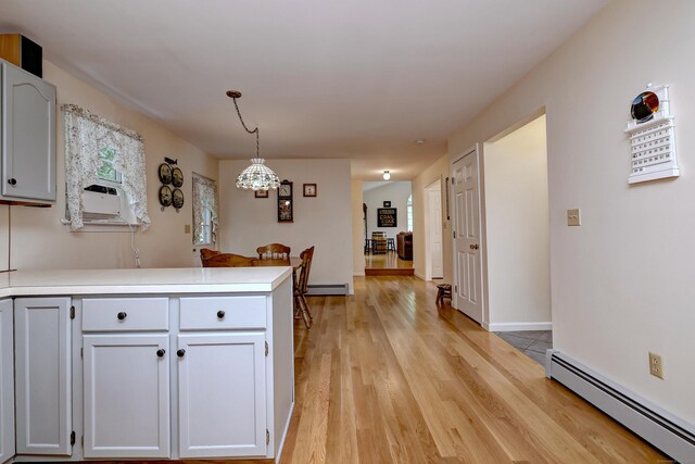 67 Nicole Dr, Naugatuck, CT 06770 - kitchen with baseboard heating, a peninsula, light wood-type flooring, and a chandelier