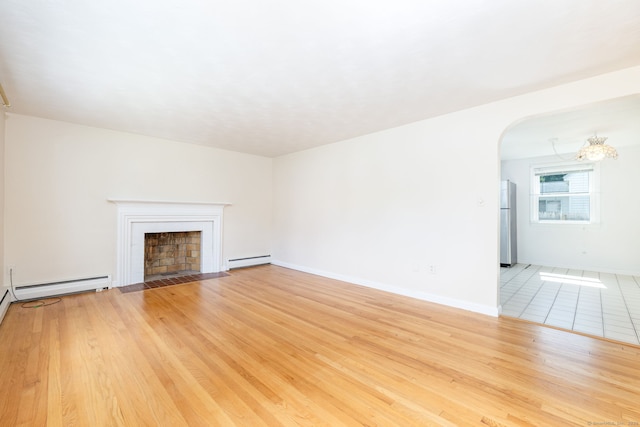 51 Euston St, New Britain, CT 06053 - unfurnished living room featuring a baseboard radiator, arched walkways, a fireplace with flush hearth, and wood finished floors