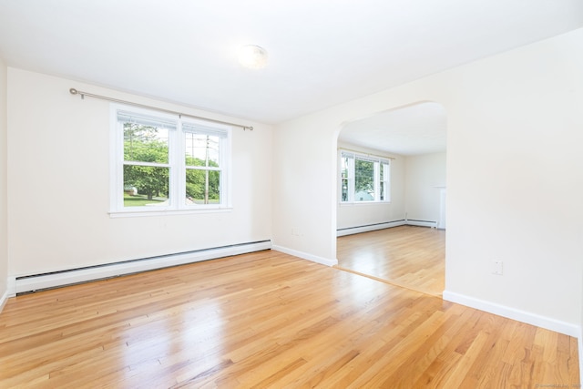 51 Euston St, New Britain, CT 06053 - spare room with baseboard heating, arched walkways, and wood finished floors