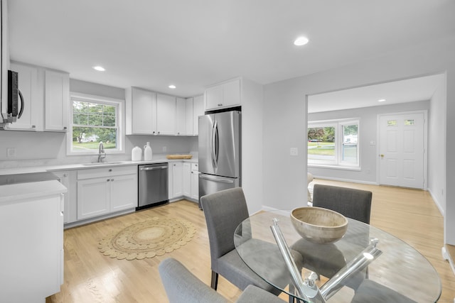 64 Ridgefield Rd, Wallingford, CT 06492 - kitchen with appliances with stainless steel finishes, light wood-style flooring, light countertops, white cabinetry, and recessed lighting