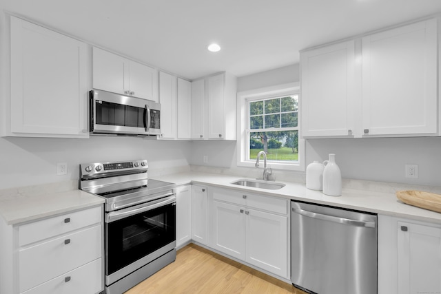 64 Ridgefield Rd, Wallingford, CT 06492 - kitchen featuring stainless steel appliances, light countertops, white cabinets, light wood-style flooring, and recessed lighting