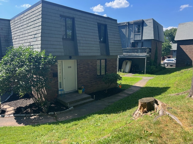 122 Trolley Crossing Ln Unit 122, Middletown, CT 06457 - rear view of house featuring brick siding, a yard, and mansard roof
