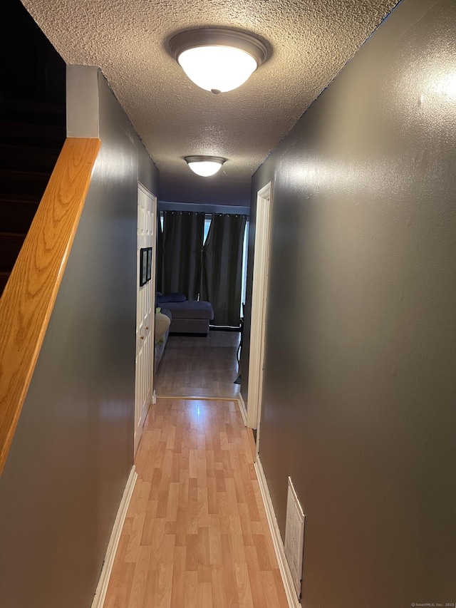 122 Trolley Crossing Ln Unit 122, Middletown, CT 06457 - hallway featuring light wood-style flooring, a textured ceiling, and stairs