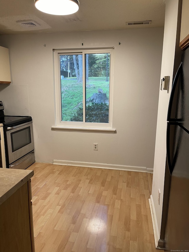 122 Trolley Crossing Ln Unit 122, Middletown, CT 06457 - kitchen featuring stainless steel electric stove, freestanding refrigerator, and light wood-type flooring