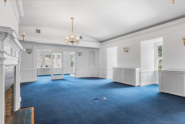 31 N Main St, Essex, CT 06426 - unfurnished living room featuring a tiled fireplace, dark colored carpet, a decorative wall, a chandelier, and vaulted ceiling