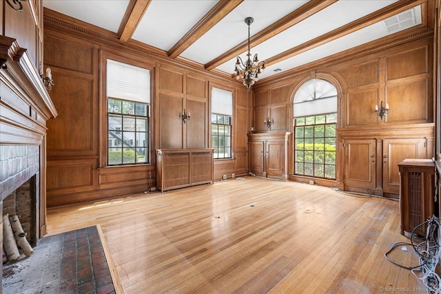 31 N Main St, Essex, CT 06426 - unfurnished living room featuring a fireplace with flush hearth, light wood-type flooring, a chandelier, a decorative wall, and beamed ceiling