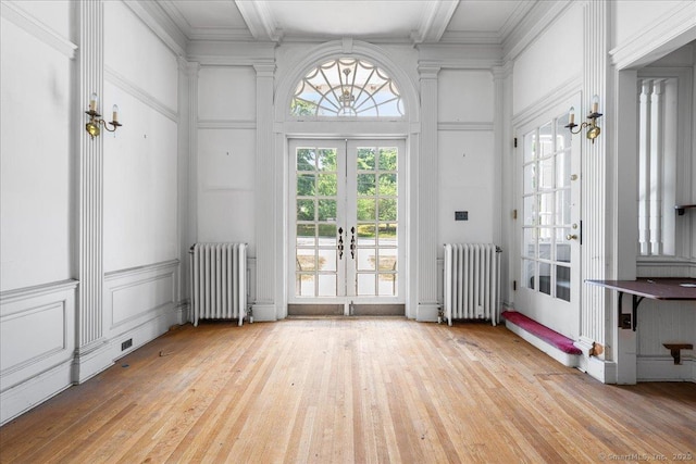 31 N Main St, Essex, CT 06426 - empty room with radiator heating unit, french doors, hardwood / wood-style flooring, a decorative wall, and plenty of natural light