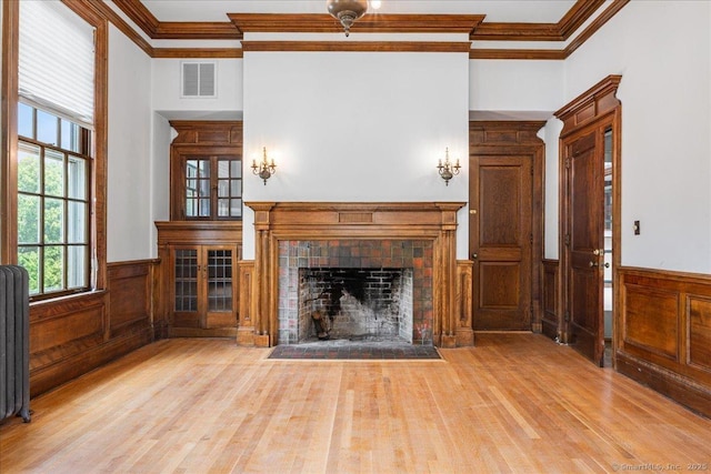 31 N Main St, Essex, CT 06426 - unfurnished living room featuring crown molding, radiator, wood finished floors, a wainscoted wall, and a fireplace with flush hearth