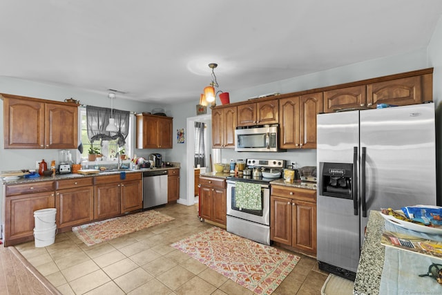 20 Society Hill Rd, Waterbury, CT 06704 - kitchen with appliances with stainless steel finishes, hanging light fixtures, brown cabinetry, and light tile patterned flooring
