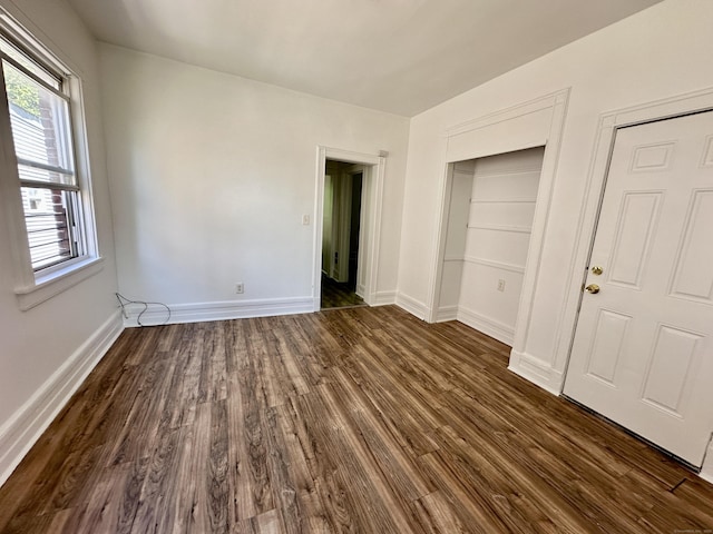 310 Bond St, Bridgeport, CT 06610 - unfurnished bedroom with dark wood-style flooring and baseboards
