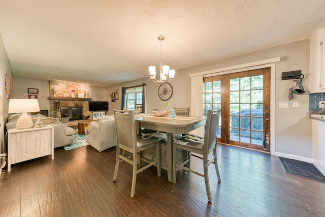 279 Annelise Ave, Southington, CT 06489 - dining room with healthy amount of natural light, dark wood-type flooring, a stone fireplace, a chandelier, and a textured ceiling
