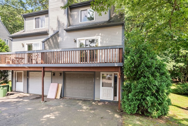65 Woodland Rdg, Meriden, CT 06450 - rear view of house featuring a garage, a chimney, and asphalt driveway