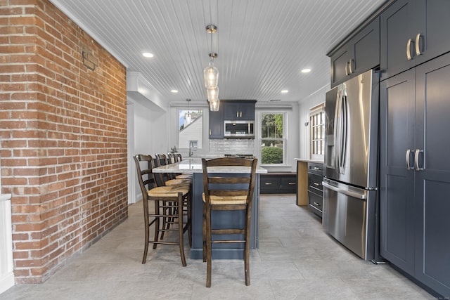 30 New Britain Rd, Old Lyme, CT 06371 - kitchen featuring appliances with stainless steel finishes, brick wall, light countertops, a breakfast bar area, and recessed lighting