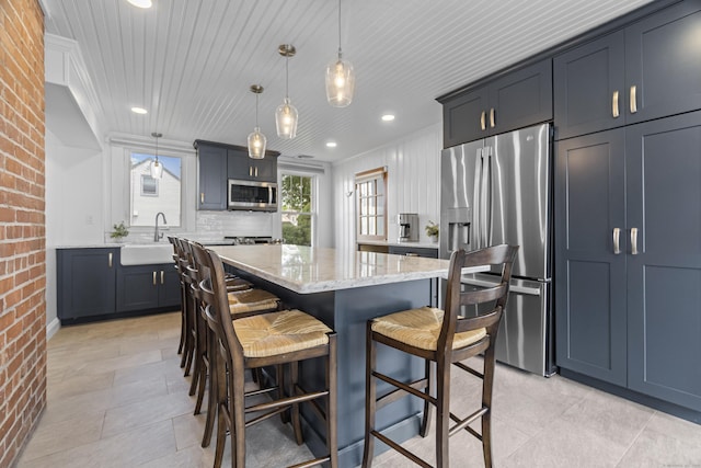 30 New Britain Rd, Old Lyme, CT 06371 - kitchen with stainless steel appliances, brick wall, light stone countertops, a kitchen bar, and a kitchen island