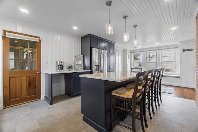 30 New Britain Rd, Old Lyme, CT 06371 - kitchen with stainless steel refrigerator with ice dispenser, light stone counters, a breakfast bar, a center island, and pendant lighting