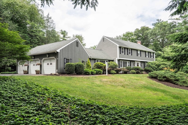341 W Mountain Rd, Simsbury, CT 06092 - colonial-style house with board and batten siding, an attached garage, a front lawn, and a chimney