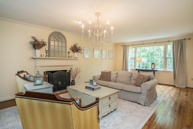 341 W Mountain Rd, Simsbury, CT 06092 - living area featuring light wood-type flooring, a chandelier, a brick fireplace, and crown molding