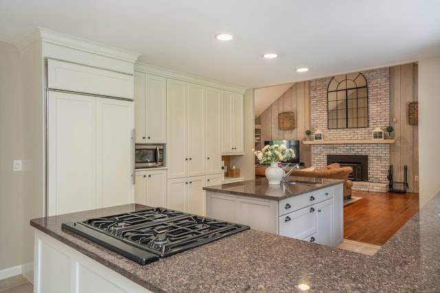 341 W Mountain Rd, Simsbury, CT 06092 - kitchen featuring black gas cooktop, a kitchen island, stainless steel microwave, dark stone counters, and recessed lighting