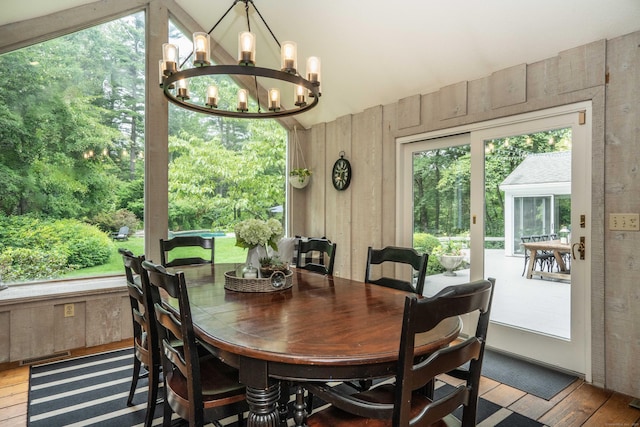 341 W Mountain Rd, Simsbury, CT 06092 - dining area with a chandelier, wood walls, wood-type flooring, and lofted ceiling