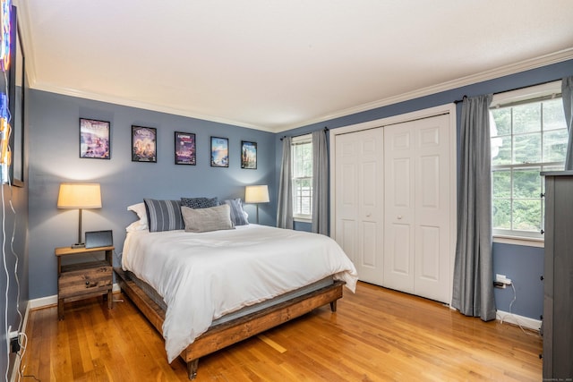 341 W Mountain Rd, Simsbury, CT 06092 - bedroom with ornamental molding, light wood-style floors, multiple windows, and a closet