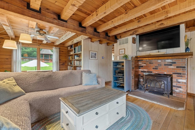 40 Devonshire Dr, Waterford, CT 06385 - living area with a wood stove, ceiling fan, hardwood / wood-style floors, a wood ceiling with exposed beams, and wood walls