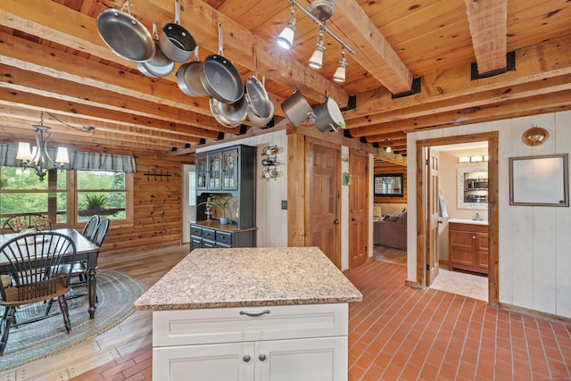 40 Devonshire Dr, Waterford, CT 06385 - kitchen featuring wood walls, white cabinets, a chandelier, light stone countertops, and a wooden ceiling with exposed beams