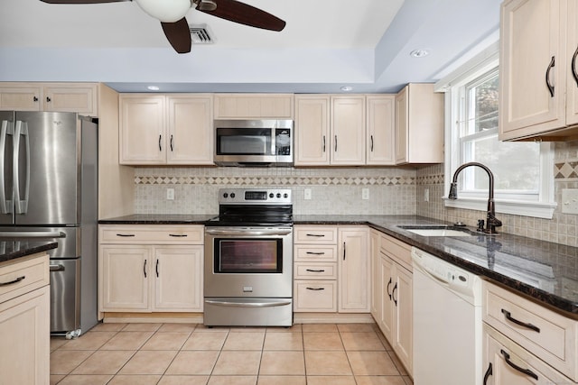 5338 Main St, Trumbull, CT 06611 - kitchen with stainless steel appliances, dark stone counters, light tile patterned floors, a ceiling fan, and decorative backsplash