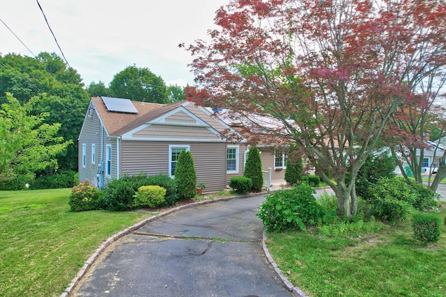 5338 Main St, Trumbull, CT 06611 - view of front of home featuring a front yard, solar panels, asphalt driveway, and a shingled roof