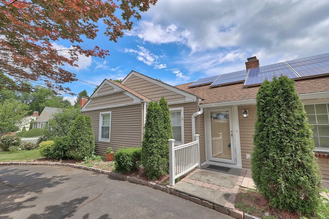 5338 Main St, Trumbull, CT 06611 - view of front of home featuring a chimney, solar panels, and roof with shingles