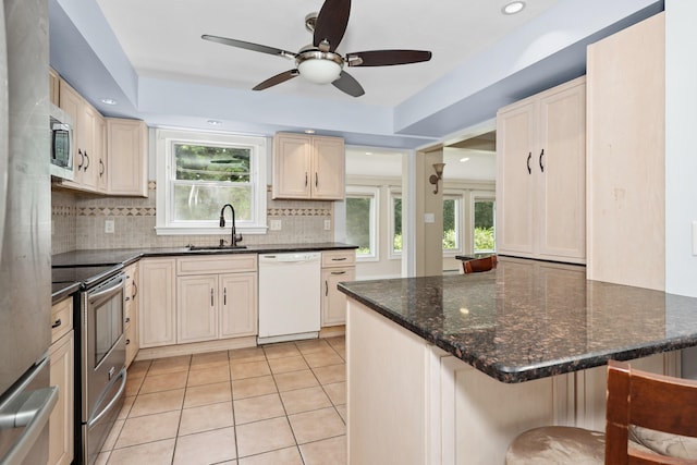 5338 Main St, Trumbull, CT 06611 - kitchen with stainless steel appliances, decorative backsplash, light tile patterned flooring, ceiling fan, and a breakfast bar area