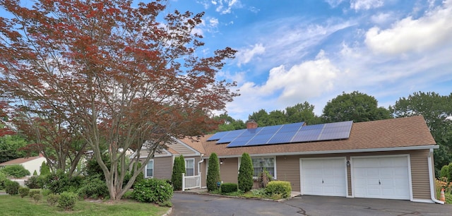 5338 Main St, Trumbull, CT 06611 - view of front of house with an attached garage, asphalt driveway, roof mounted solar panels, a chimney, and roof with shingles