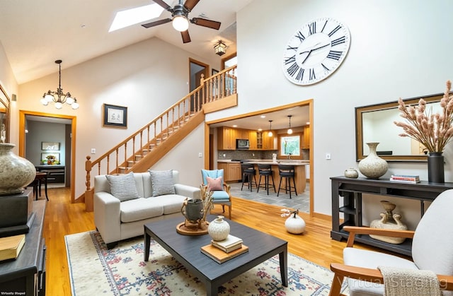 53 Princeton Dr, Middletown, CT 06457 - living area with stairs, light wood-style flooring, a ceiling fan, a chandelier, and a skylight