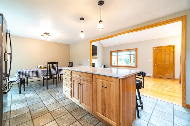 53 Princeton Dr, Middletown, CT 06457 - kitchen with freestanding refrigerator, a kitchen breakfast bar, light countertops, a textured ceiling, and decorative light fixtures