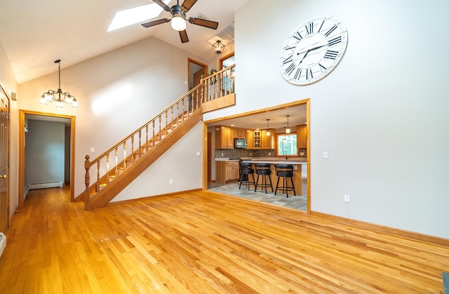 53 Princeton Dr, Middletown, CT 06457 - living room with light wood-style flooring, stairs, a skylight, a ceiling fan, and high vaulted ceiling