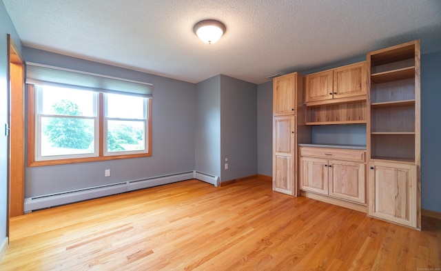 53 Princeton Dr, Middletown, CT 06457 - unfurnished living room featuring baseboard heating, light wood-type flooring, and a textured ceiling