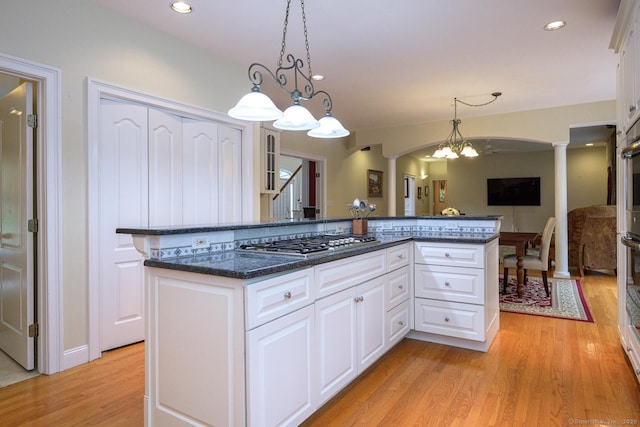 20 Portage Xing, Farmington, CT 06032 - kitchen with stainless steel gas cooktop, ornate columns, arched walkways, light wood-style floors, and white cabinetry
