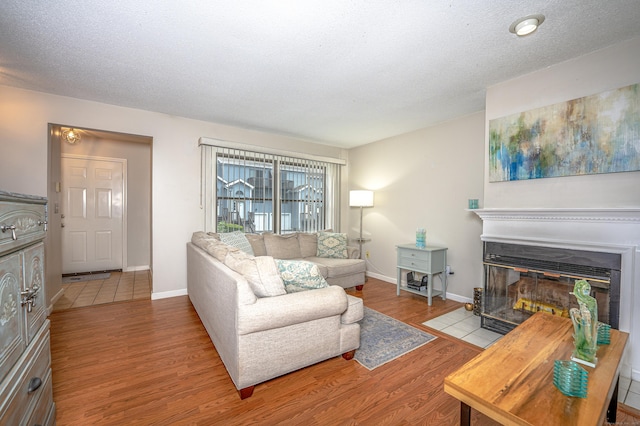 708 Lake Vista Dr Unit 708, East Hampton, CT 06424 - living room featuring wood finished floors, a fireplace with flush hearth, and a textured ceiling