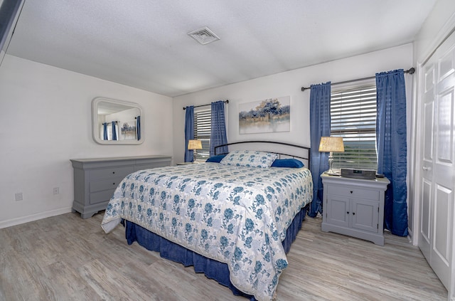 708 Lake Vista Dr Unit 708, East Hampton, CT 06424 - bedroom featuring multiple windows, light wood-style floors, and a textured ceiling