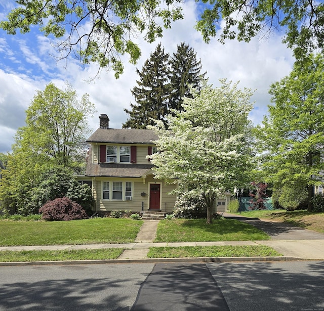 36 Winthrop Ter, Meriden, CT 06451 - view of front of home with concrete driveway, a chimney, and a front lawn