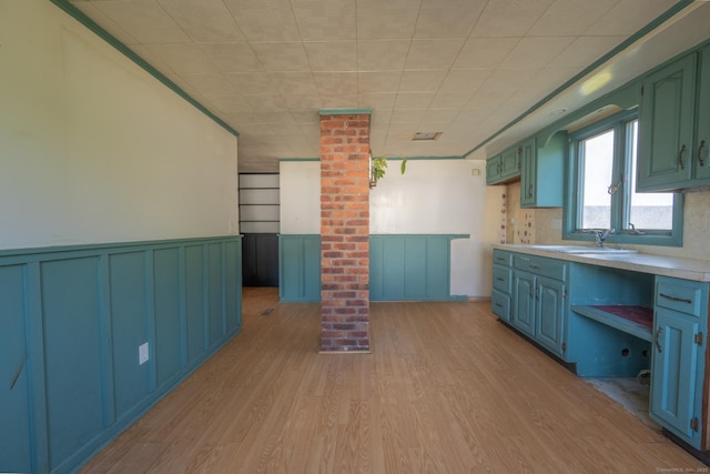 102 Vista Dr, East Haven, CT 06512 - kitchen with light countertops, light wood-style floors, a wainscoted wall, decorative columns, and blue cabinets