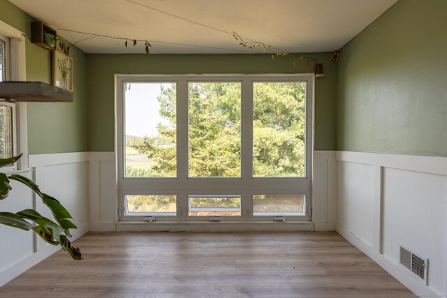 102 Vista Dr, East Haven, CT 06512 - spare room featuring a wainscoted wall, healthy amount of natural light, a decorative wall, and light wood-type flooring