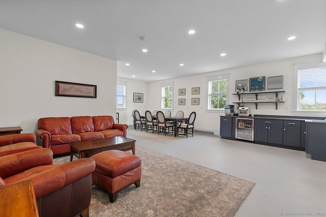 2 Ashby St, Groton, CT 06355 - living area featuring beverage cooler, bar with sink, finished concrete flooring, recessed lighting, and healthy amount of natural light