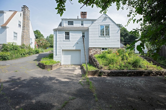53 Haviland St, Bristol, CT 06010 - back of house featuring asphalt driveway, a chimney, and a garage