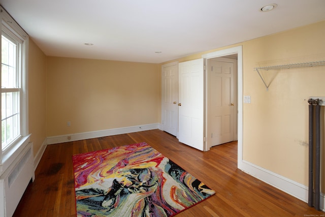 53 Haviland St, Bristol, CT 06010 - unfurnished bedroom with radiator, wood finished floors, multiple windows, and recessed lighting