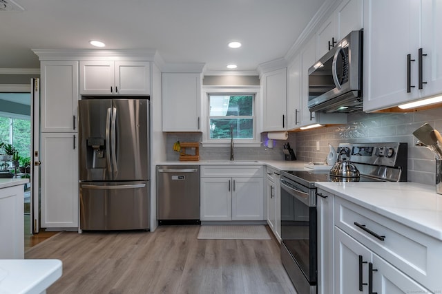 28 Musket Ridge Rd, New Fairfield, CT 06812 - kitchen featuring stainless steel appliances, ornamental molding, white cabinetry, light countertops, and light wood-style floors