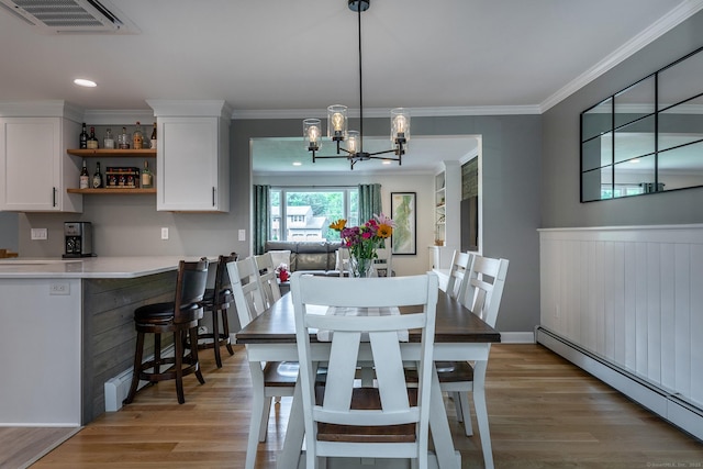 28 Musket Ridge Rd, New Fairfield, CT 06812 - dining area with a baseboard heating unit, light wood-type flooring, a chandelier, ornamental molding, and bar area