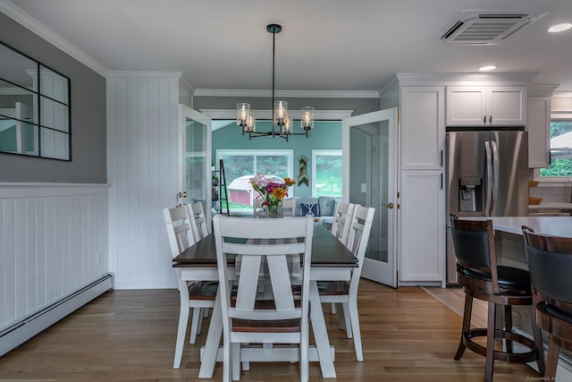 28 Musket Ridge Rd, New Fairfield, CT 06812 - dining room with baseboard heating, wood finished floors, a chandelier, ornamental molding, and a wainscoted wall
