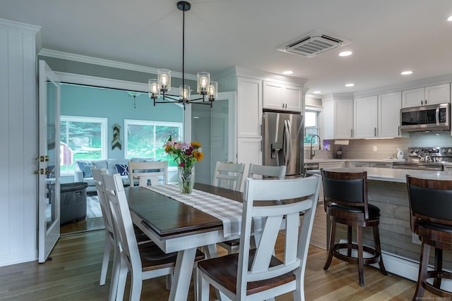 28 Musket Ridge Rd, New Fairfield, CT 06812 - dining space with light wood finished floors, ornamental molding, a chandelier, and recessed lighting