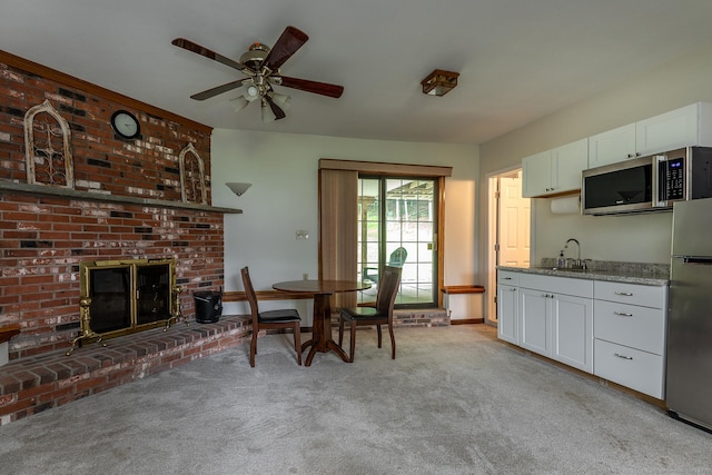 28 Musket Ridge Rd, New Fairfield, CT 06812 - dining space with light colored carpet, a fireplace, and a ceiling fan